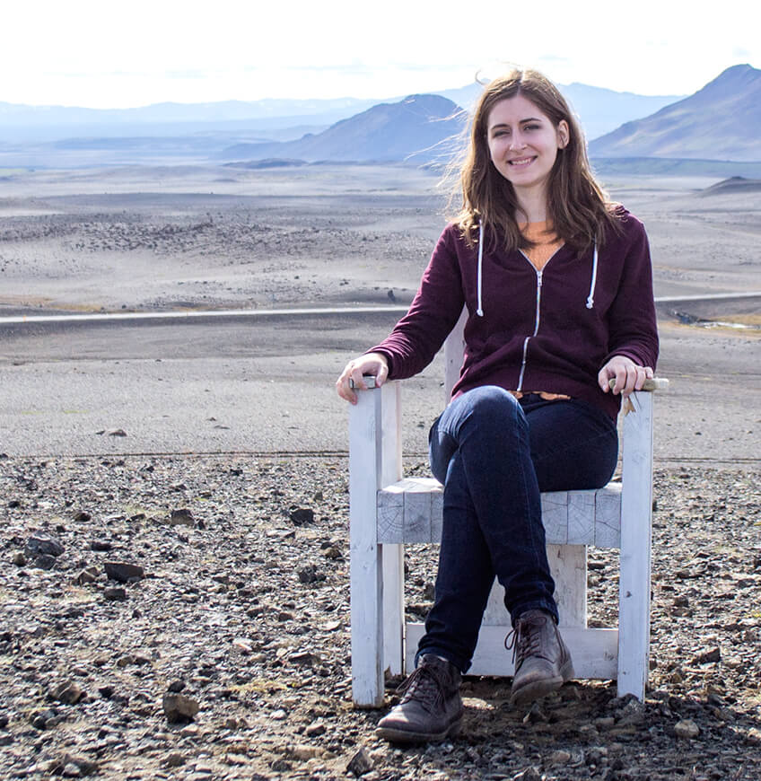 Emily sitting in a chair found on a hill in rural, mountainous northern Iceland.